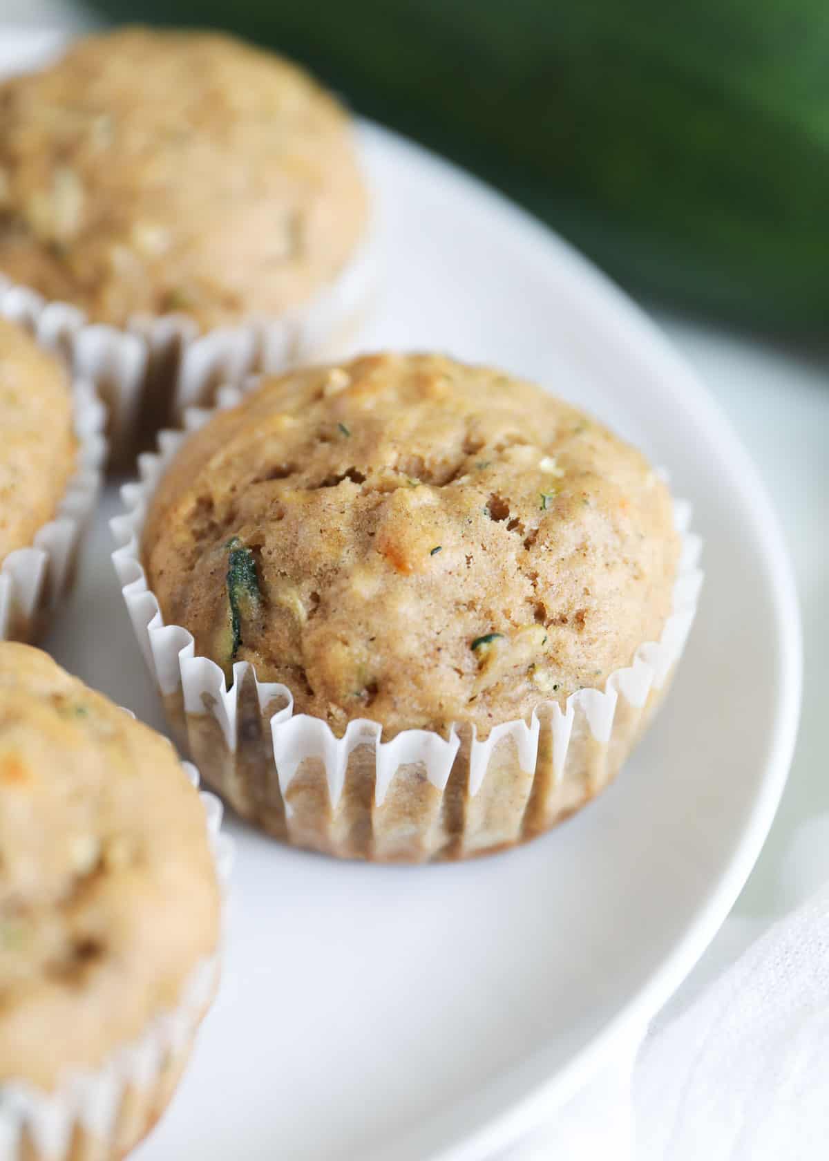 Banana zucchini muffins on white plate.