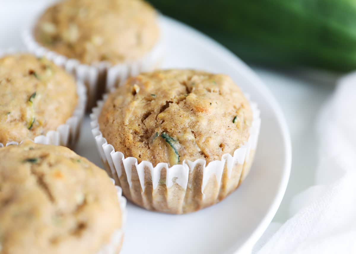 Banana zucchini muffins on white plate.