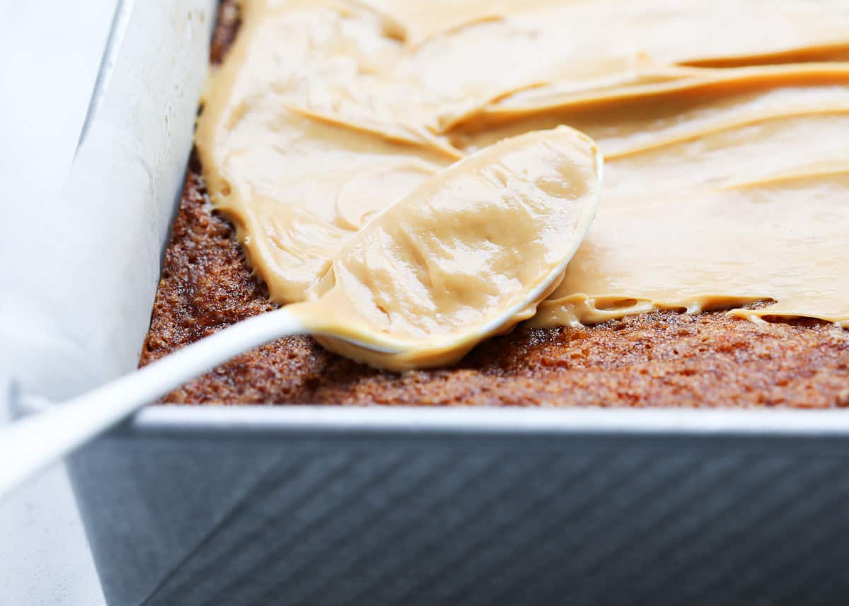 A cake in a pan with caramel cream cheese frosting. 