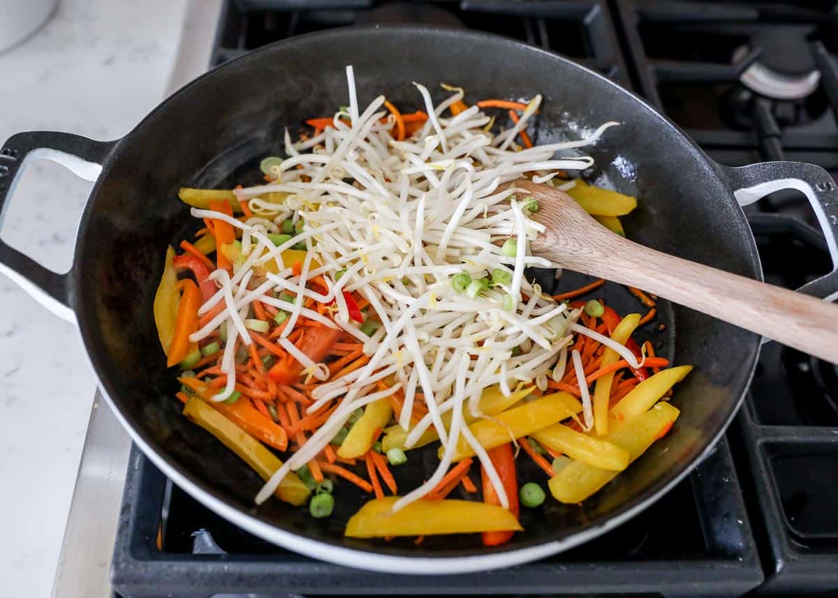 Stir frying bean sprouts and veggies for chicken pad thai.