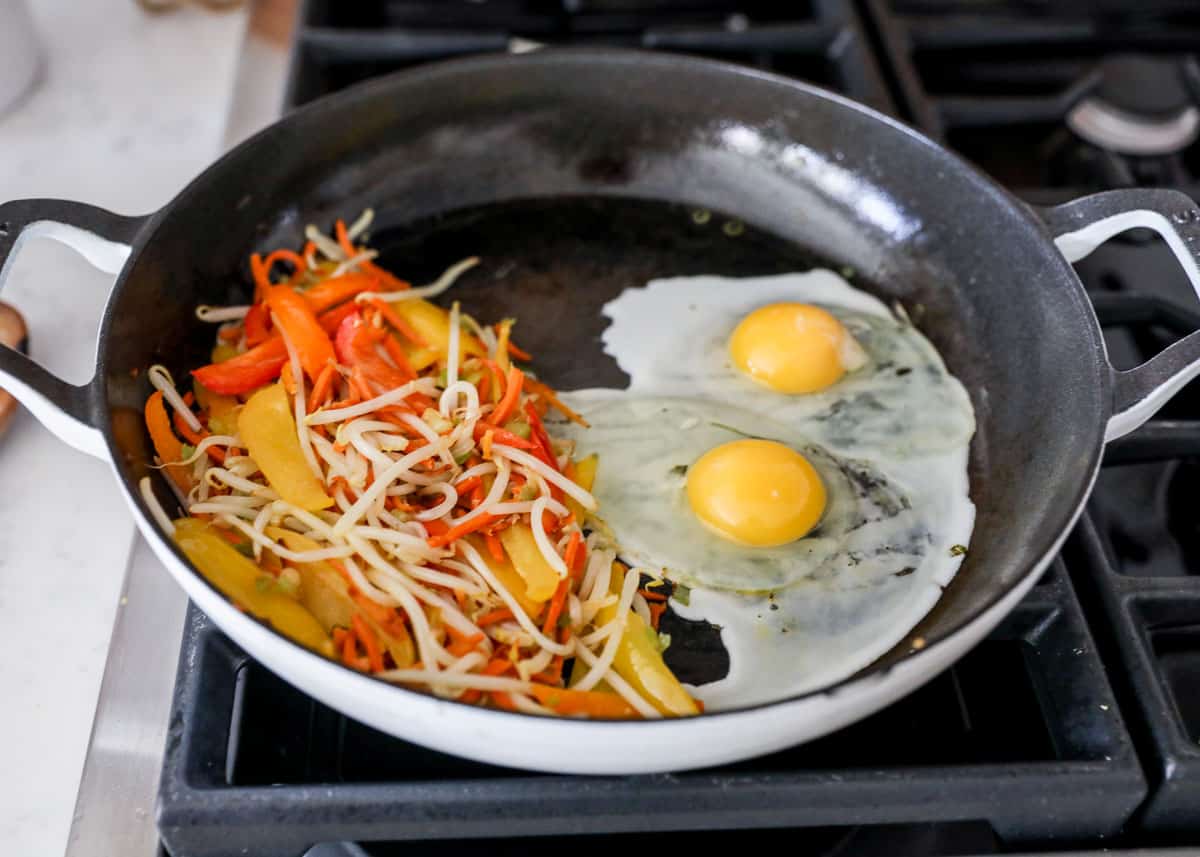 Eggs in a skillet with pad thai ingredients.
