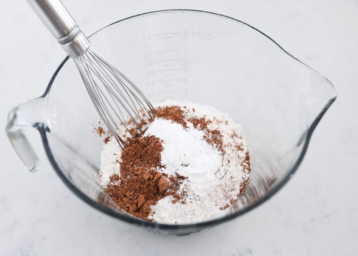 Whisking flour and cocoa powder in glass bowl.