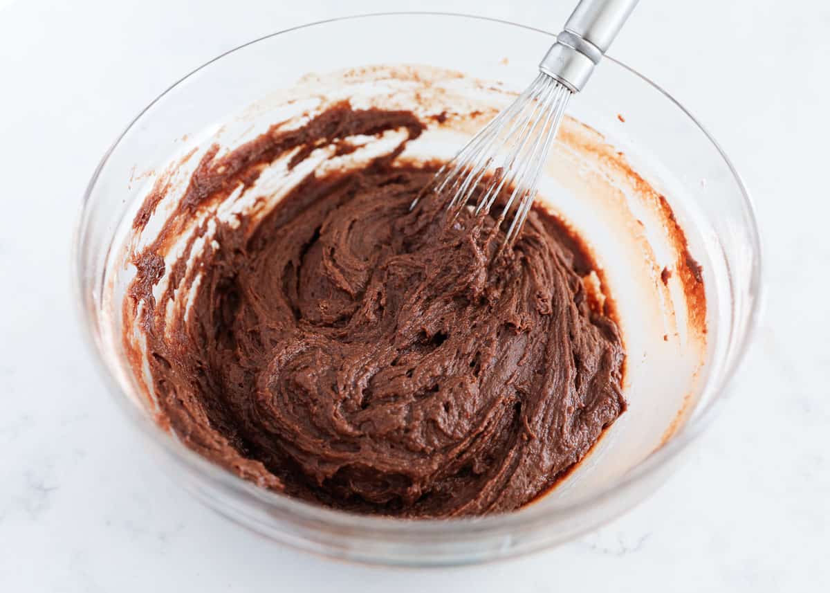 Whisking chocolate batter in glass bowl.