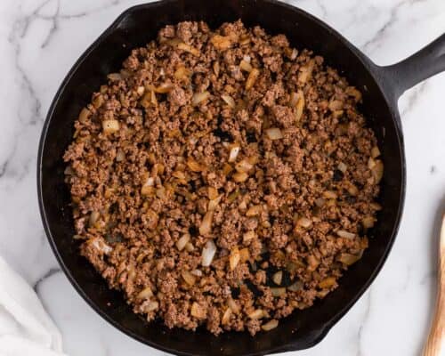 cooking hamburger and onions in skillet