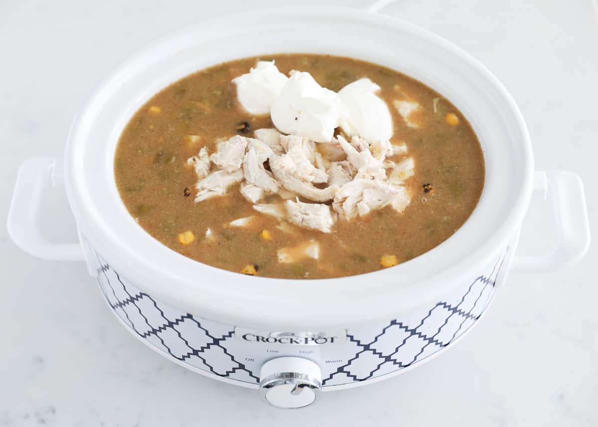 Green enchilada chicken soup in slow cooker with cream cheese.