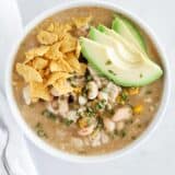 green enchilada chicken soup in bowl with avocado