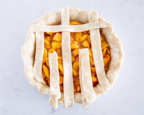 weaving pie crust on top of peach pie