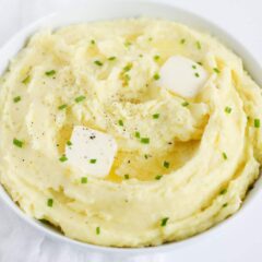 mashed potatoes in white bowl with butter