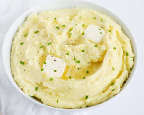 mashed potatoes in white bowl with butter