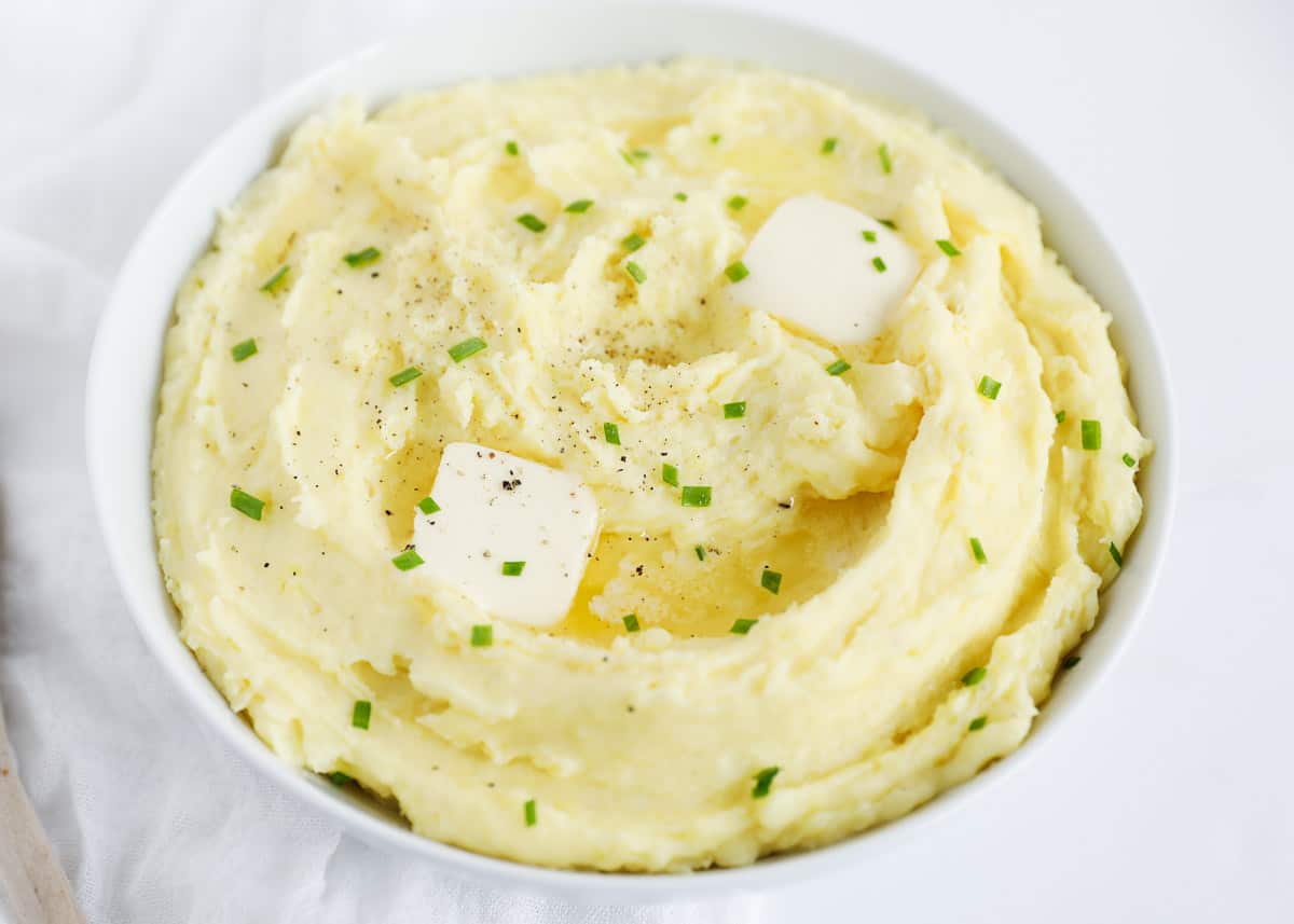 mashed potatoes in white bowl with butter