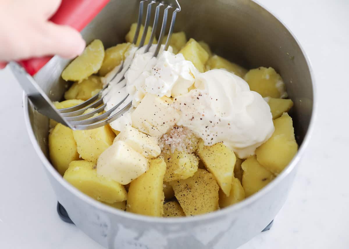 mashing potatoes in pot 