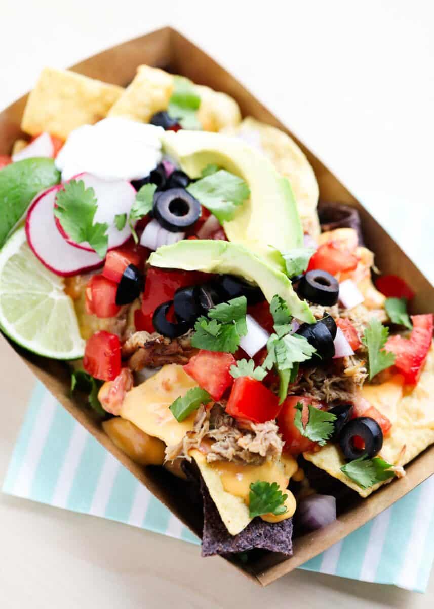 nachos with toppings in cardboard container