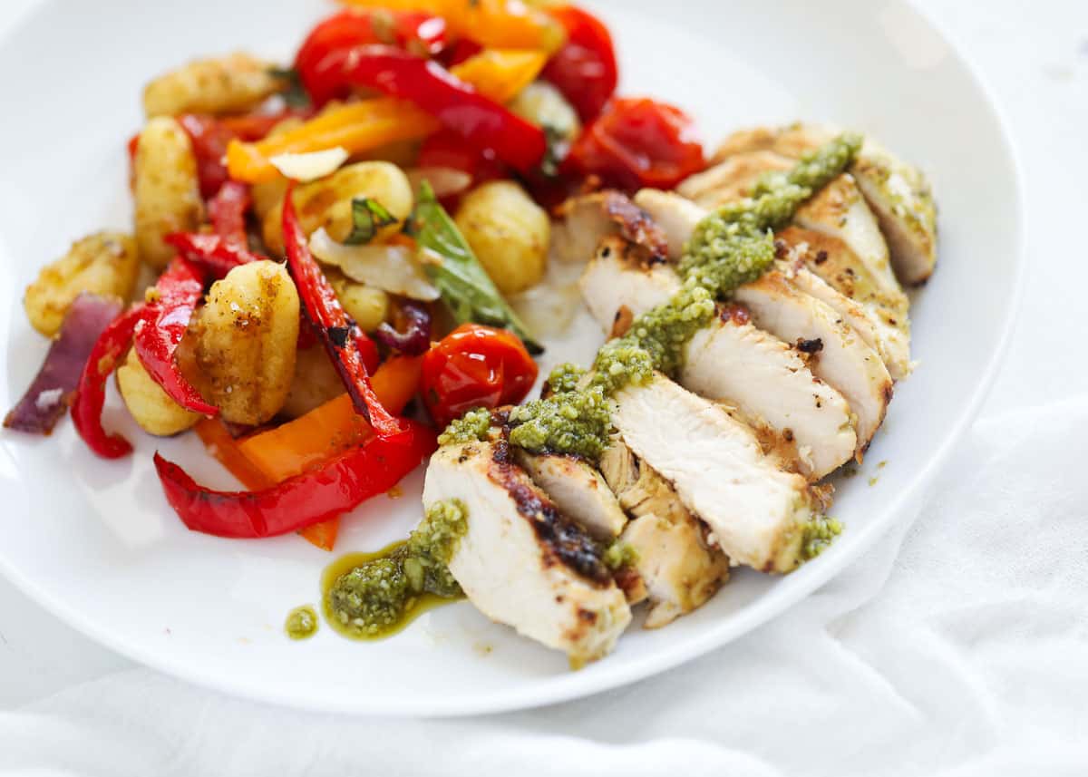 sliced pesto chicken on plate with vegetables