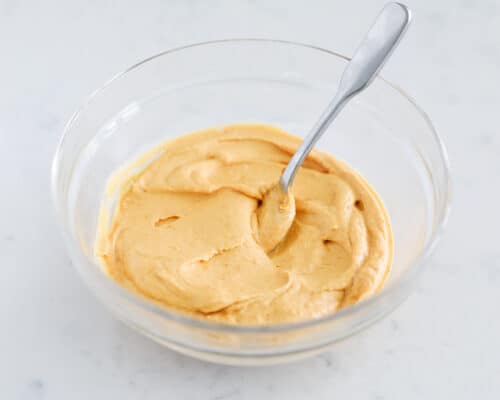 mixing pumpkin dip in glass bowl