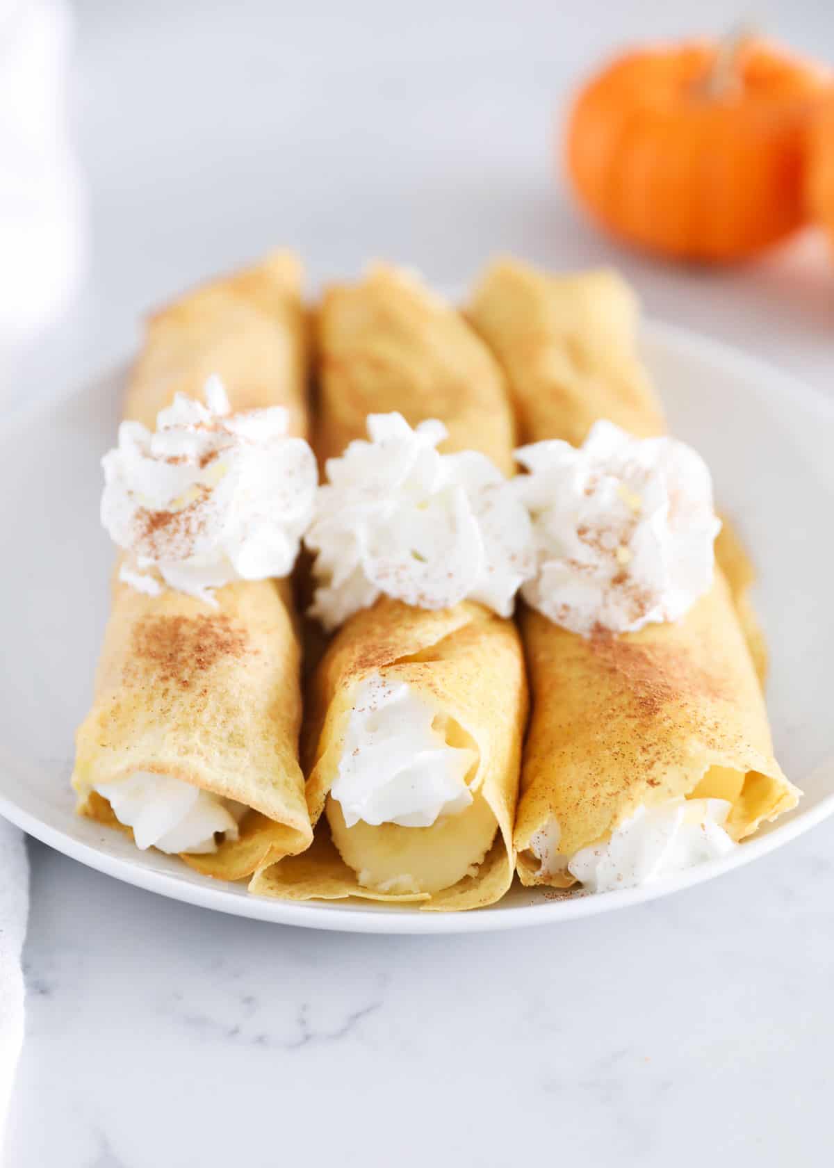 rolled pumpkin crepes with whipped cream
