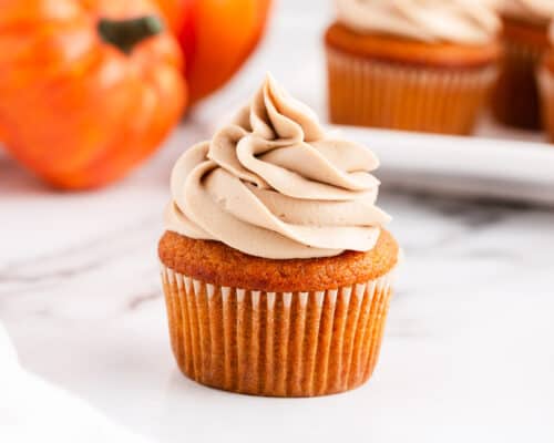 frosted pumpkin cupcake on counter
