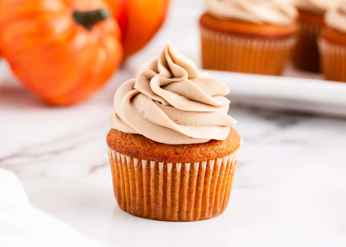 frosted pumpkin cupcake on counter