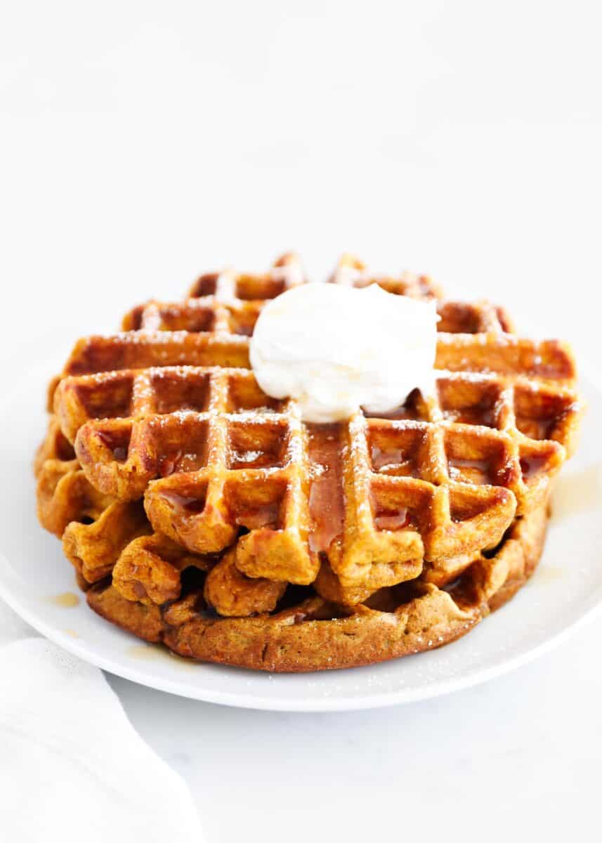 pumpkin waffles stacked on white plate