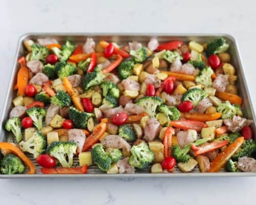 prepping chicken and vegetables on sheet pan