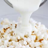 pouring white chocolate over popcorn