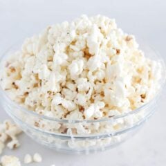 White chocolate popcorn in a clear bowl for snacking.