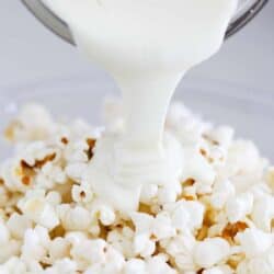 pouring white chocolate over popcorn