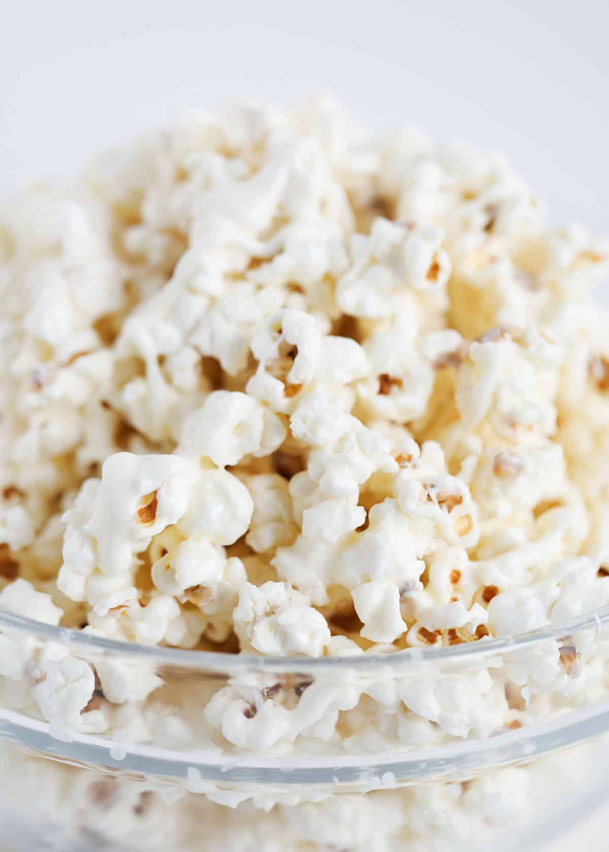 This delicious white chocolate popcorn is the perfect sweet treat for an afternoon snack or movie night. It's easy to make in 10 minutes and would make a great holiday gift, too! white chocolate popcorn in bowl