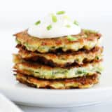 stack of zucchini fritters with sour cream