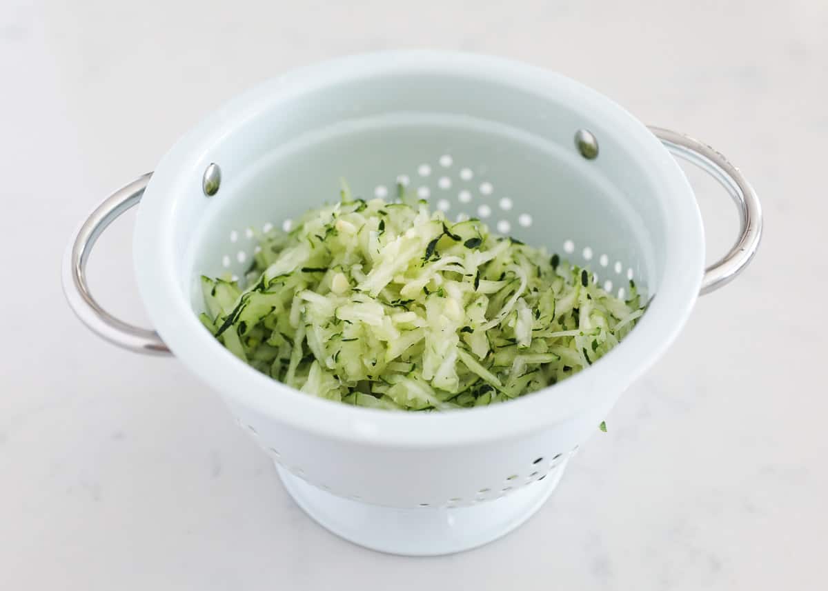 Grated zucchini in colander.