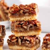 Stacked pecan bars on counter.
