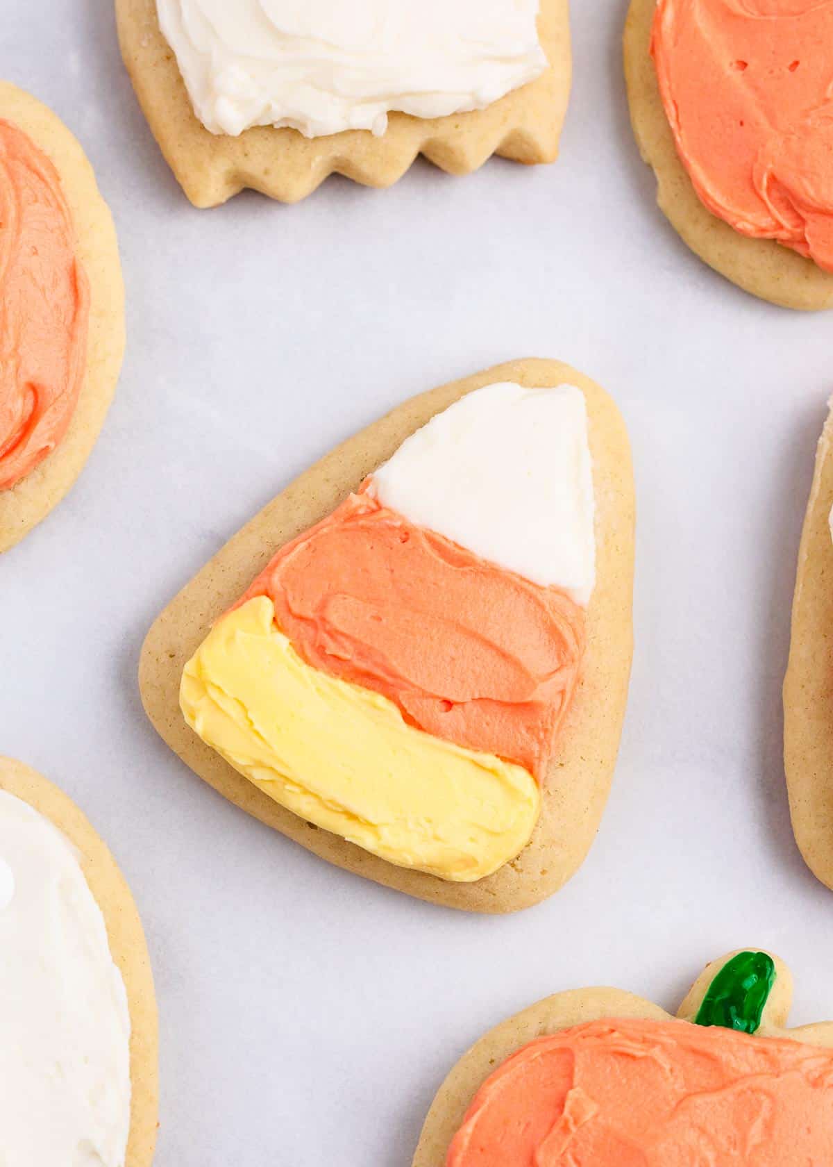 Halloween sugar cookies decorated like candy corn on the counter. 