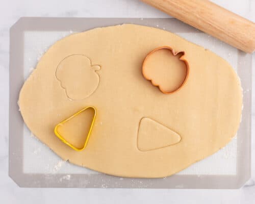 cutting sugar cookies out with cookie cutters