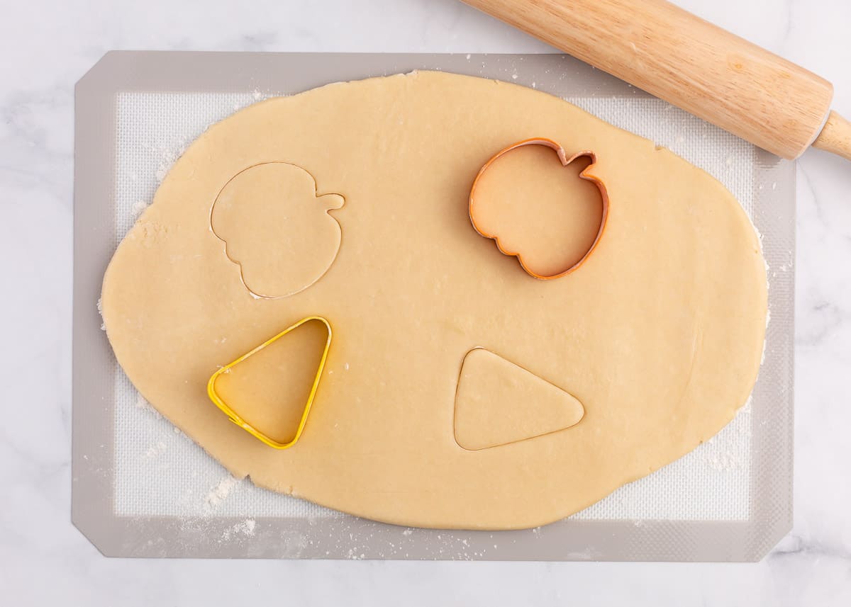 cutting sugar cookies out with cookie cutters