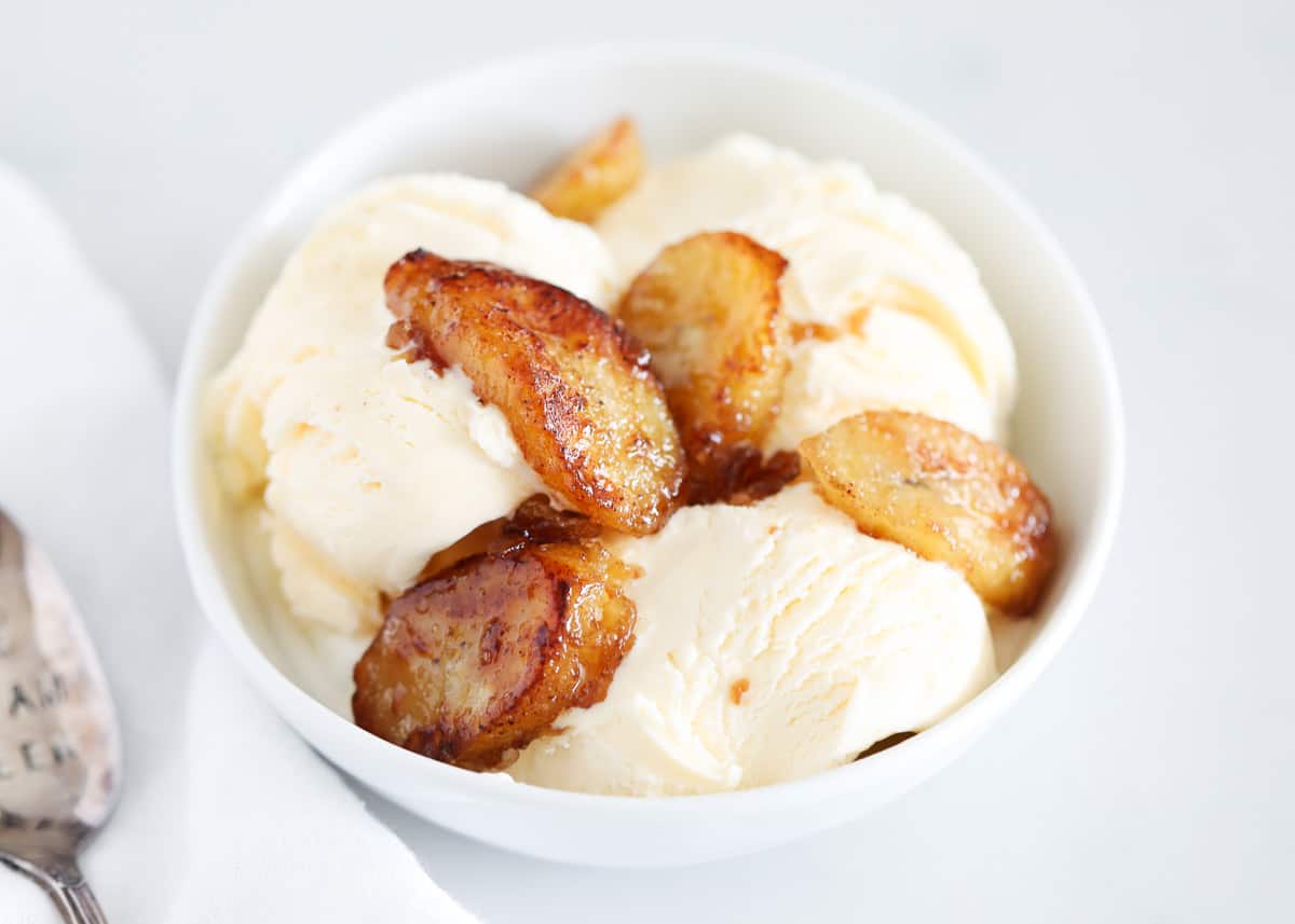 Caramelized bananas are are an easy 5-minute sweet treat whose tastes and textures will have you swooning. Use this irresistible topping on your ice cream and waffles or enjoy a bowl on its own! bowl of ice cream with caramelized bananas