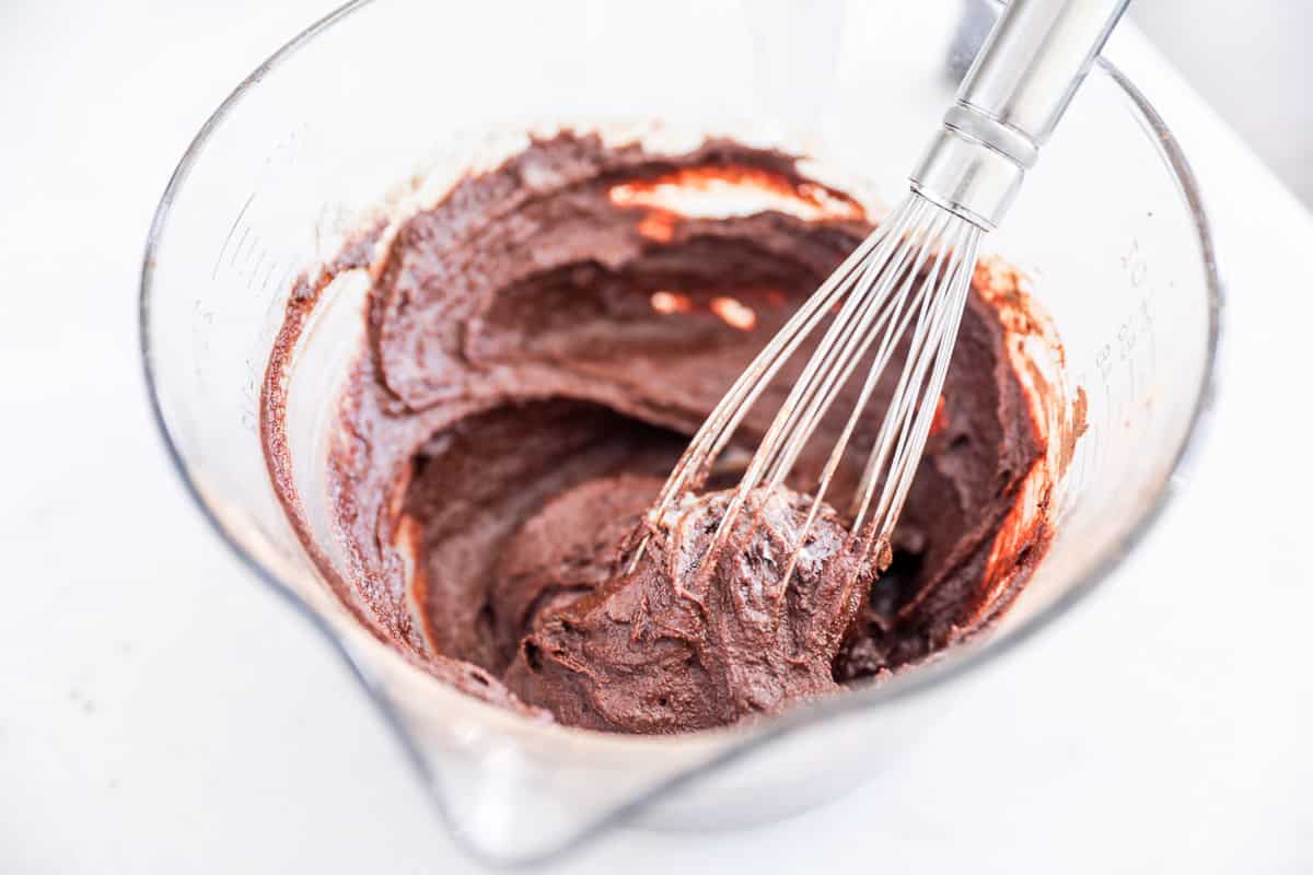 whisking chocolate into glass bowl
