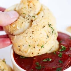 dipping garlic knot in marinara