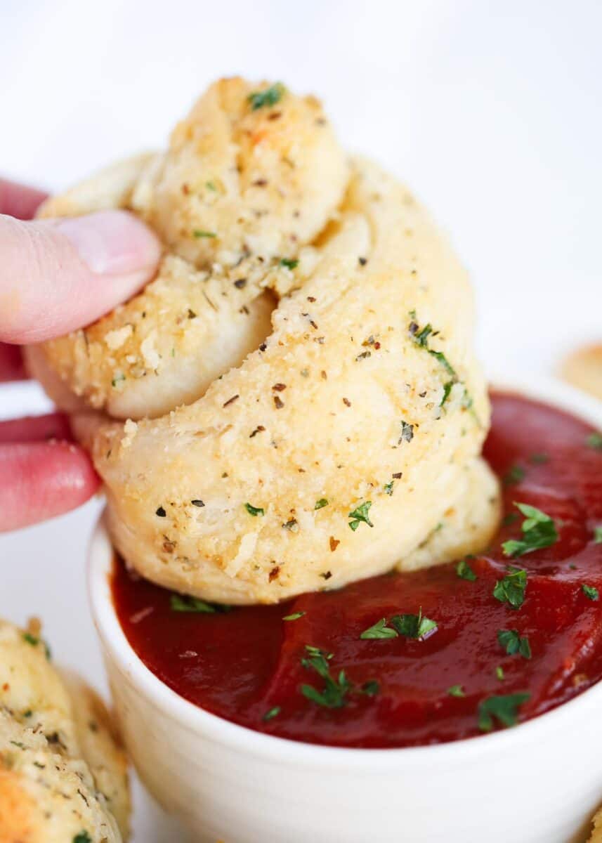 dipping garlic knot in marinara