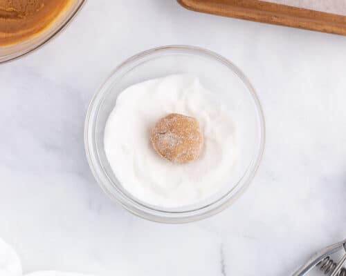 peanut butter ball being rolled in sugar