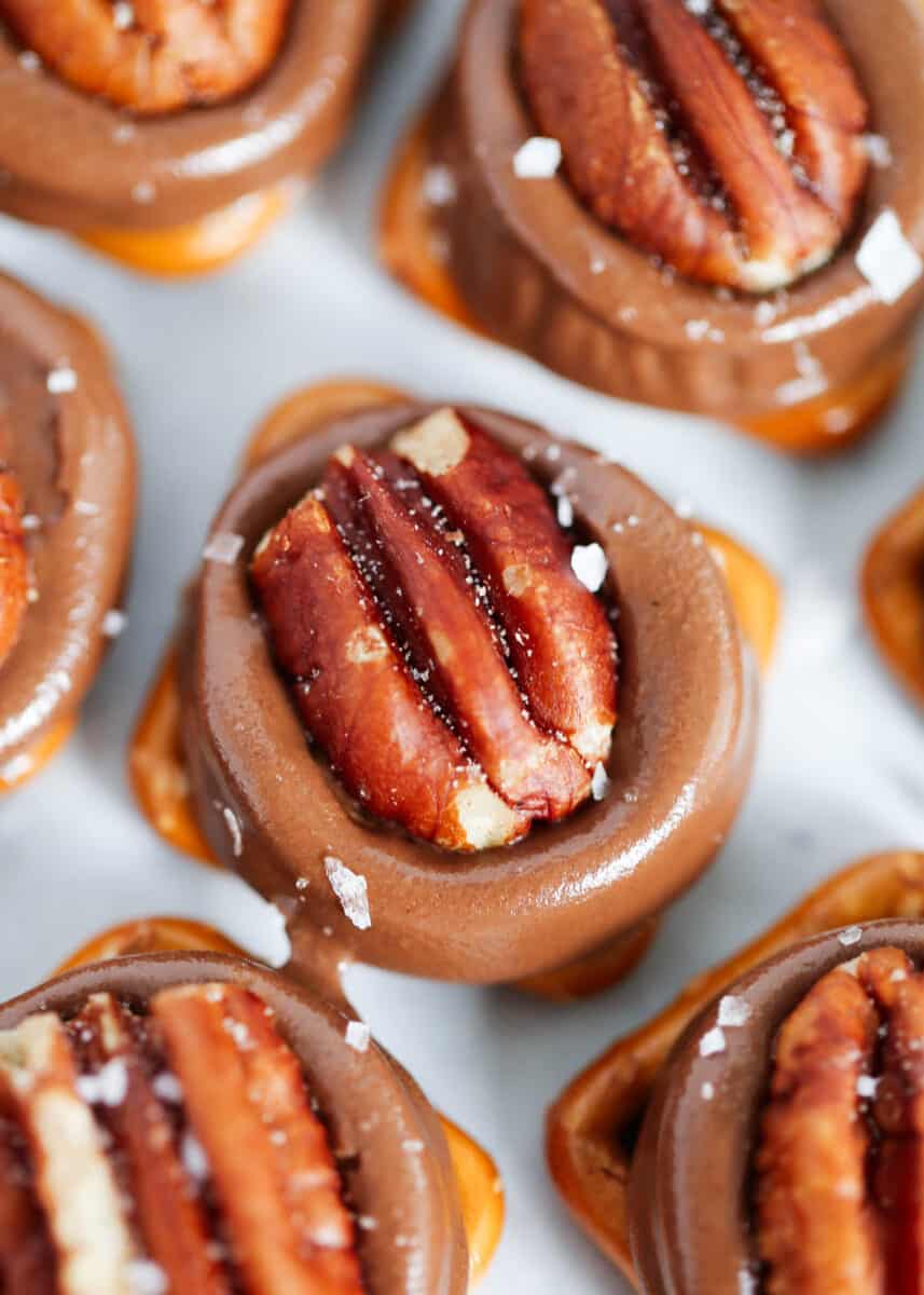 Sweet and salty Rolo pretzel turtles made with only 3 ingredients in less than 15 minutes! This quick and easy dessert is the perfect no-fuss treat to enjoy this Christmas. rolo pretzel turtle with pecan on top