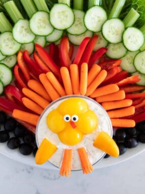 Thanksgiving turkey veggie platter arranged with cucumbers, celery, peppers, carrots, and a turkey-shaped ranch dip.