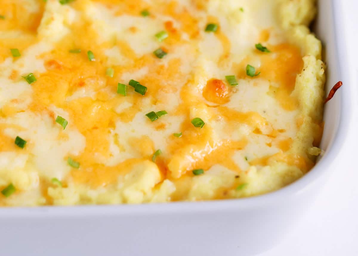 Cheesy mashed potatoes in a dish.