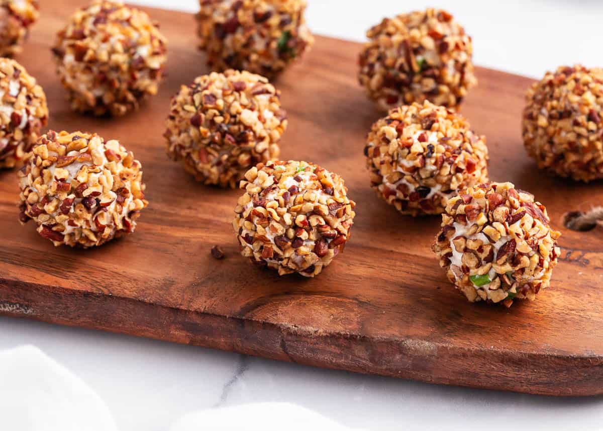 Cheese ball bites are flavorful appetizers that are perfect for snacking or serving at parties. These mini cheese balls are loaded with everyone's favorite ingredients, and they are incredibly simple to make. cheeseball bites on board