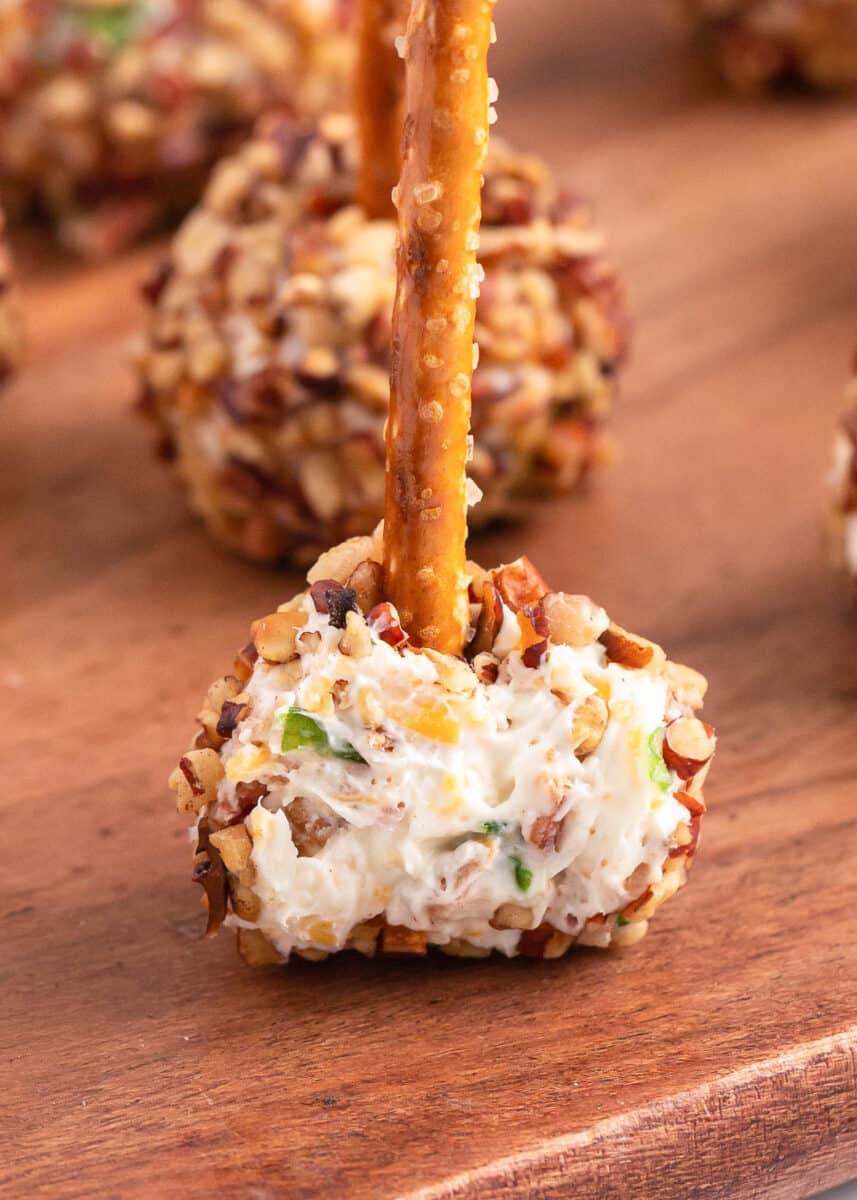 Cheese ball bites are flavorful appetizers that are perfect for snacking or serving at parties. These mini cheese balls are loaded with everyone's favorite ingredients, and they are incredibly simple to make. cheeseball bite bitten into