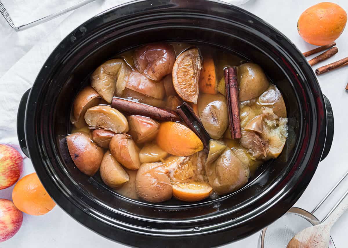 Cooked fruit and spices in crockpot for apple cider.