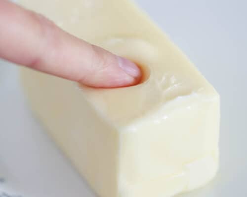 pressing finger into softened butter