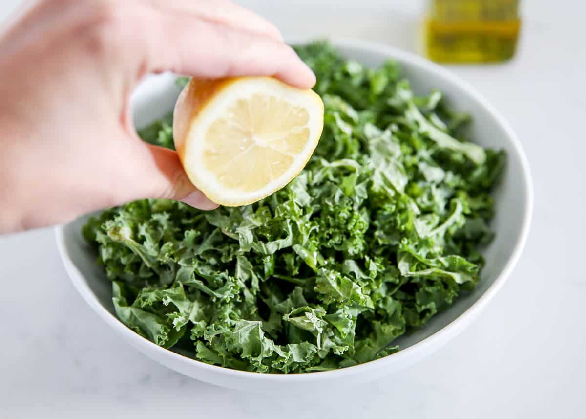 squeezing lemon into kale salad