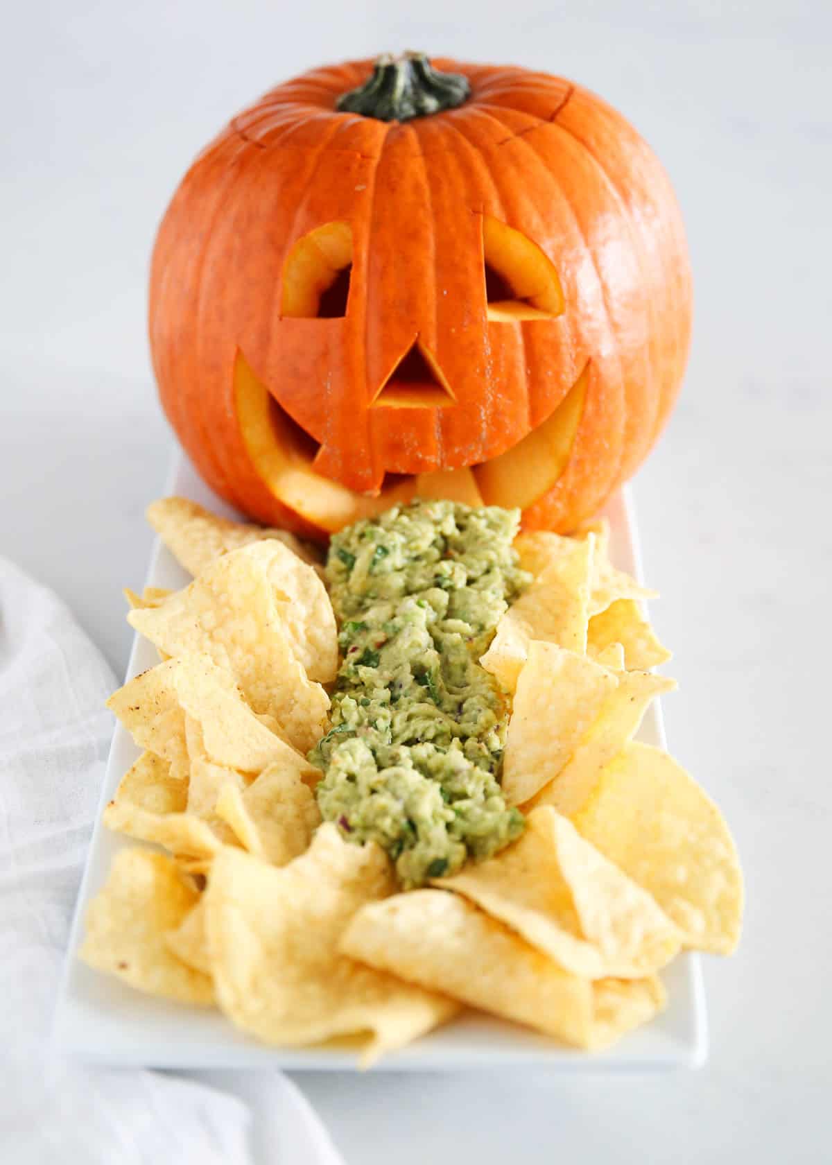 A jack-o-lantern puking guacamole for a hilarious Halloween snack idea.
