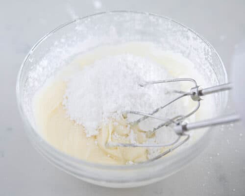 mixing icing together in glass bowl
