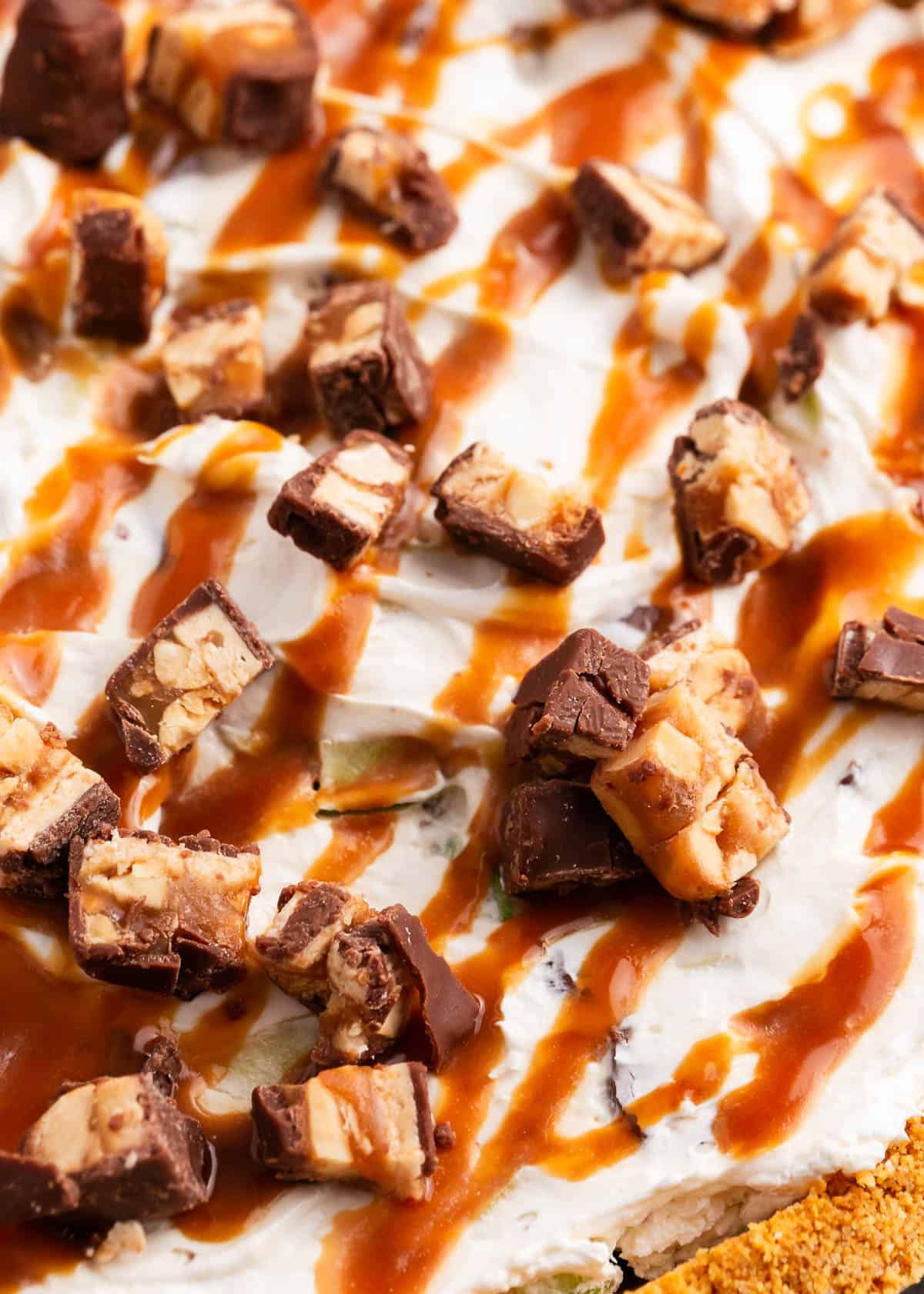 Snickers and caramel on top of pie.