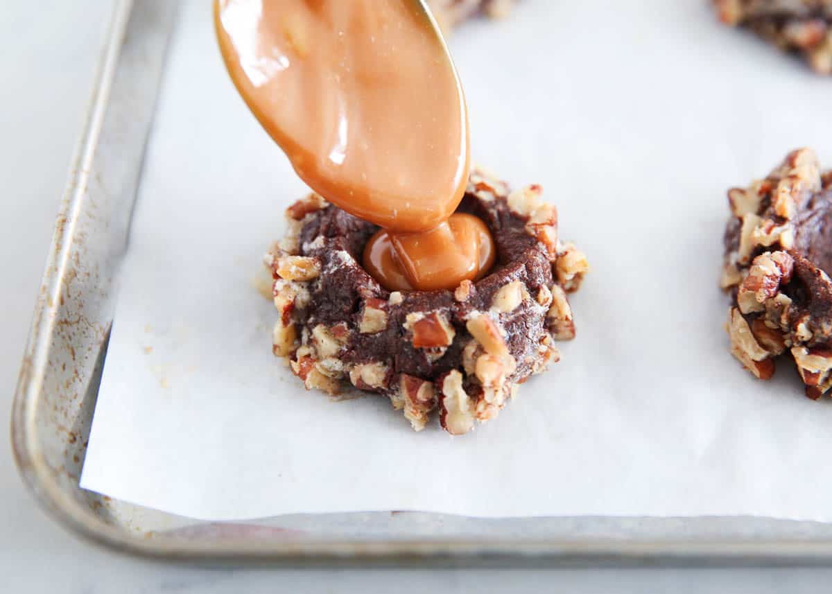 pouring caramel onto cookie